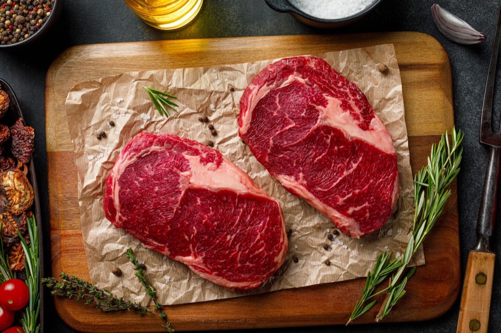 まな板の上の生の牛肉。赤身と脂の境目に白い筋が見える