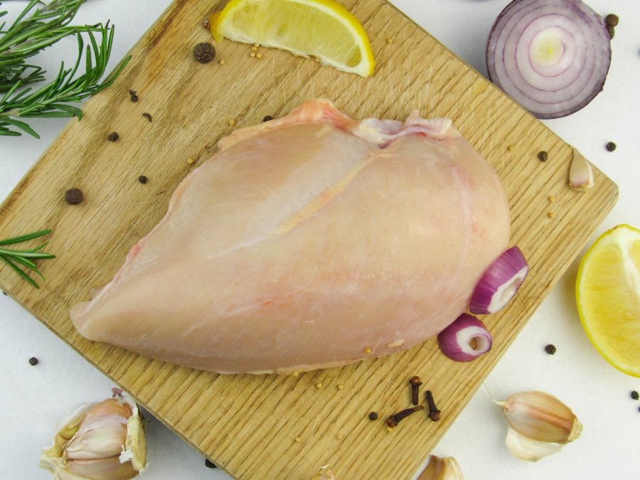 まな板の上の鶏むね肉。ほんのり透けるようなピンク色が新しい証拠
